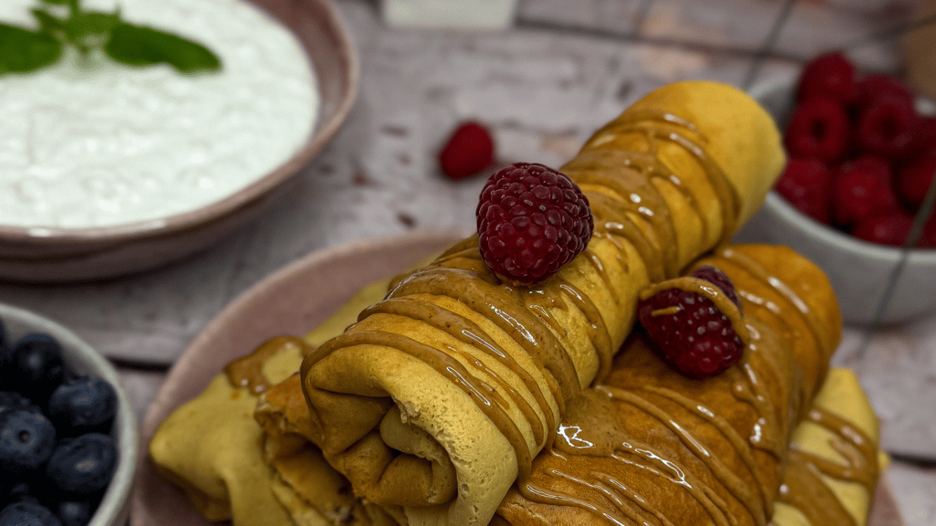 bezglutenowe wysokobiałkowe naleśniki na słodko z pastą pistacjową i malinami