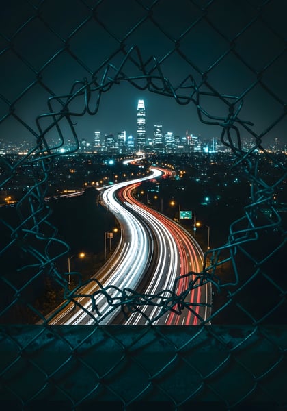 UMA CIDADE DE NOITE COM UMA CERCA DE METAL ABERTA 02