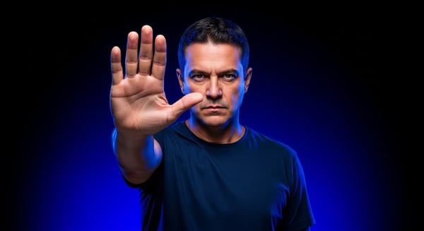 HOMEM SRIOD FAZENDO GESTO DE PARE COM A MO EM FUNDO AZUL CONCEITO DE LIMITE E PROIBIÇÃO