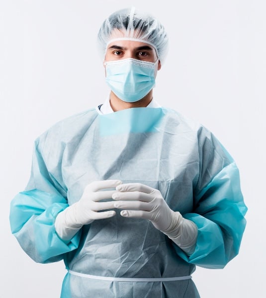 MÉDICO EM TRAJE CIRÚRGICO COMPLETO, COM MÁSCARA E LUVAS, POSTURA CONFIANTE, FUNDO BRANCO