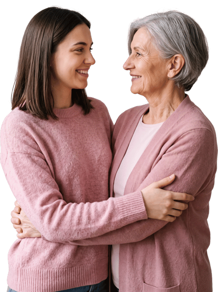 YOUNG WOMAN AND ELDERLY LADY SMILING WHILE EMBRACING