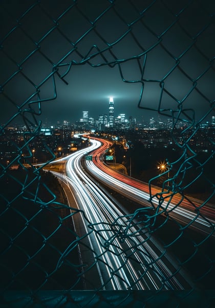 UMA CIDADE DE NOITE COM UMA CERCA DE METAL ABERTA 04