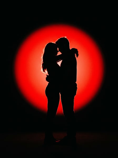 CASAL DE NAMORADOS COM UM BRILHO VERMELHO AO FUNDO 01