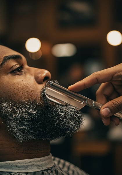 BARBEIRO USANDO NAVALHA CLÁSSICA PARA DEFINIR O CONTORNO DA BARBA DE UM HOMEM NEGRO