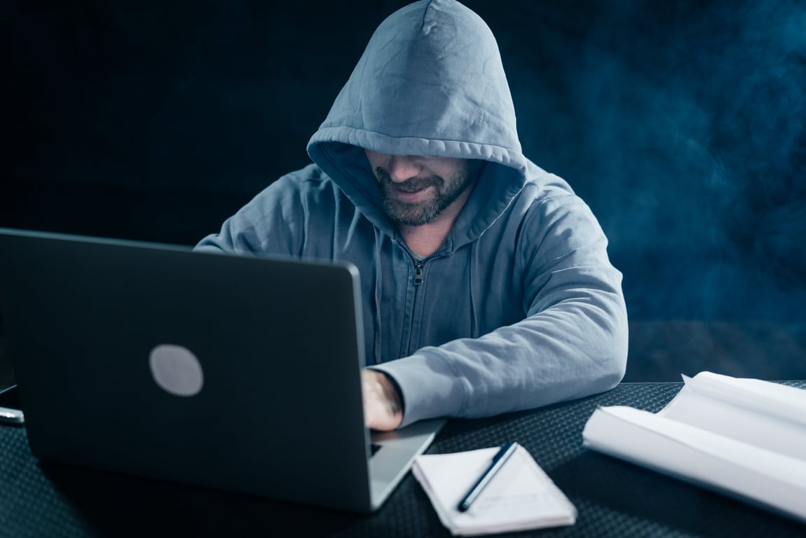 האקר יושב מול המחשב בחושך