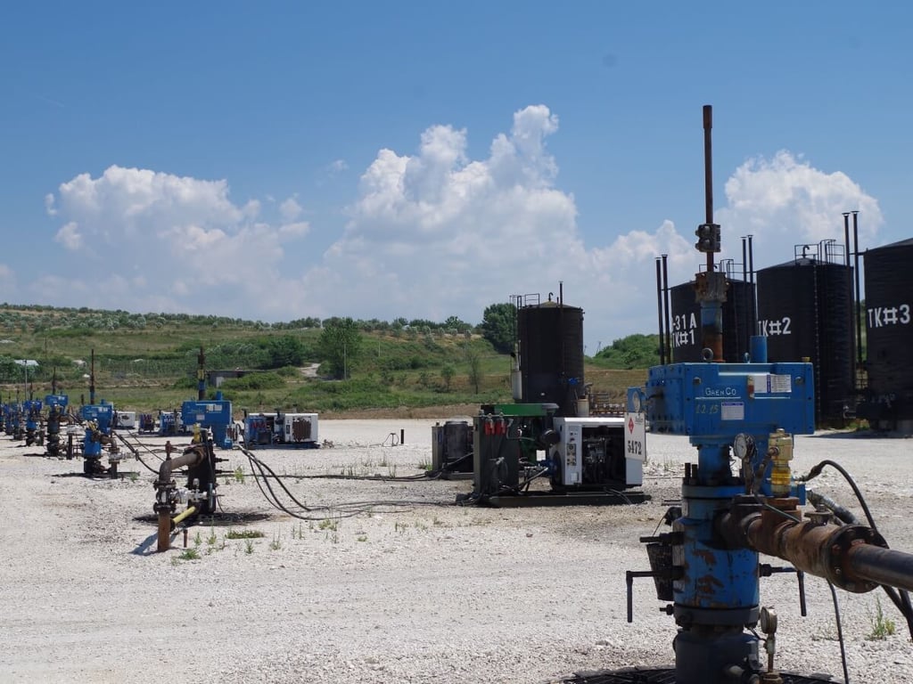 Pamje e një pjese të sheshit me depozita, kokat e pusit dhe gjeneratorët elektrikë