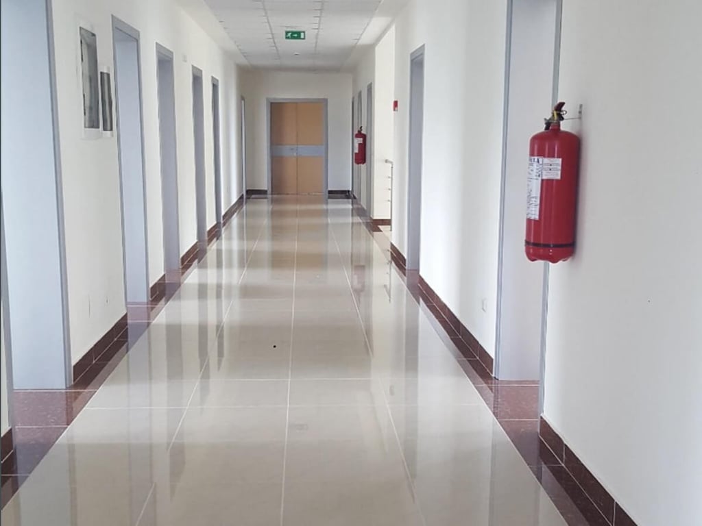 Ambiente të brendshme të qendrës shëndetësore me tabelat e evakuimit dhe bombulat kundër zjarrit