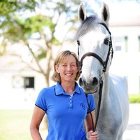 Anne Kursinski with a grey horse — trainer and clinician portrait