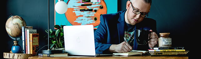 jaykay-dowdall-rhims9-course-creator-marketing-expert-working-on-laptop-with-notebook