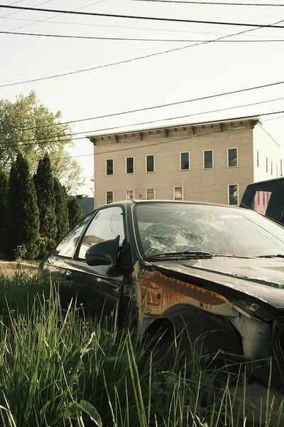 Scrap car being loaded onto a tow truck for hauling