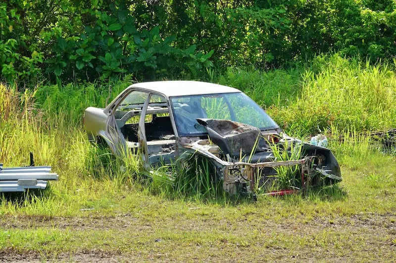 Scrap car being loaded onto a tow truck for hauling