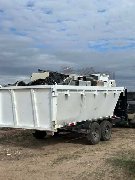 Junk removal truck hauling debris from a property
