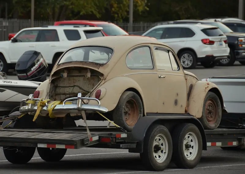 Scrap car being loaded onto a tow truck for hauling