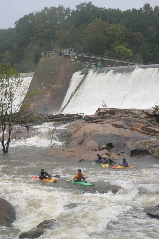 A crowd watches from the dam. 