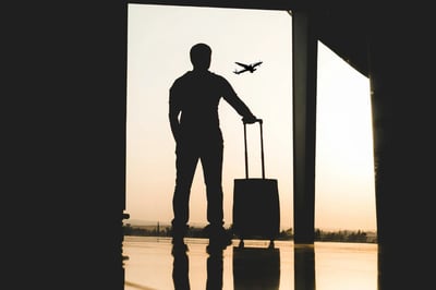 Silhouette of a man with a suitcase at an airport, symbolizing life transitions and new beginnings
