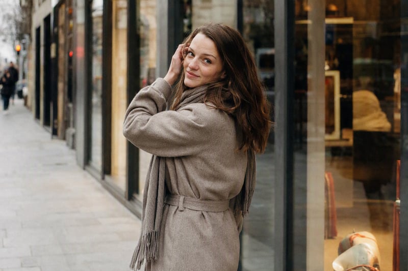 Woman standing at an angle to camera in soft afternoon light, weight on back foot