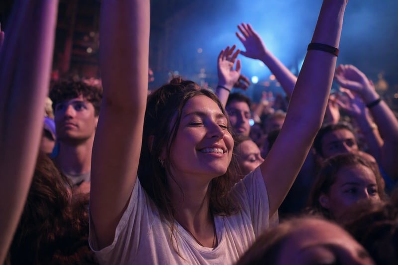 A performer under saturated blue and red stage light seen from the crowd, grainy