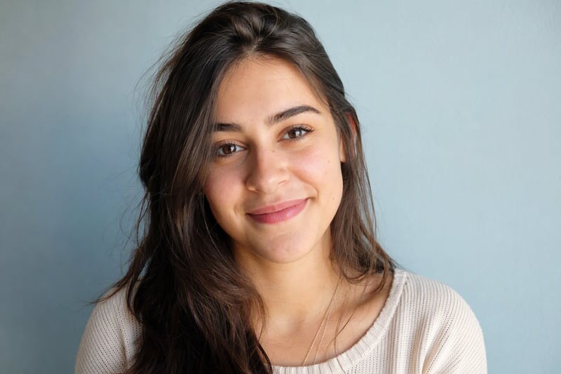 Head and shoulders portrait against a plain wall lit by a large window
