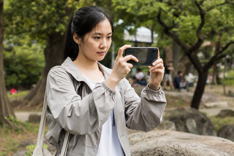 Two friends looking at a phone screen comparing an original photo with an edit