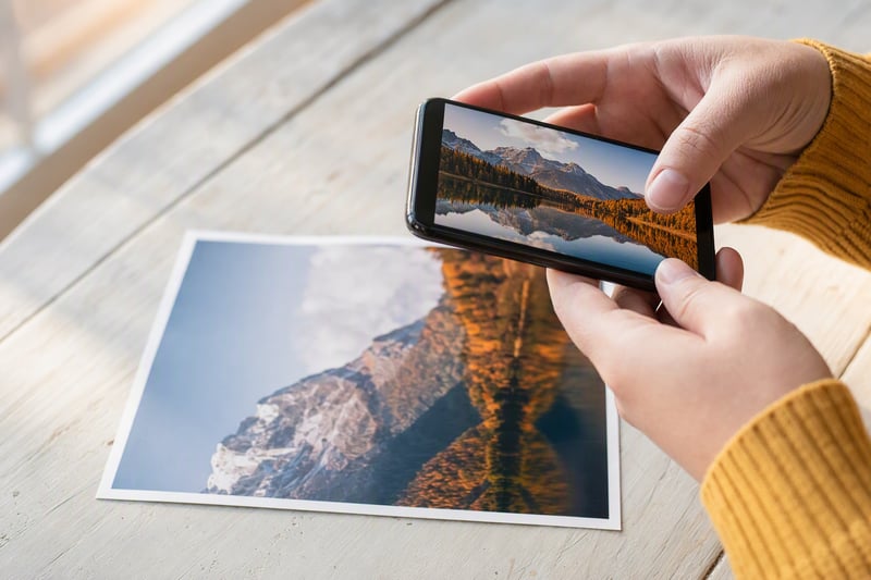 A woman comparing two versions of the same portrait side by side on a phone screen