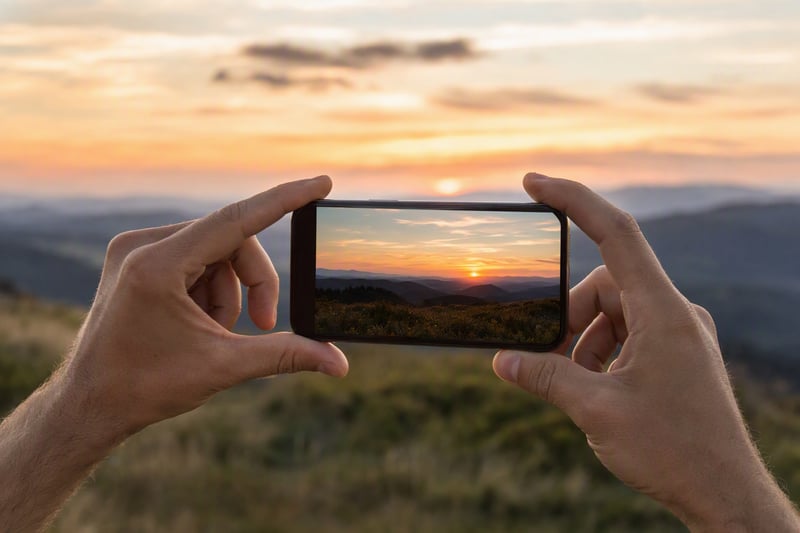 Close view of hands adjusting camera controls on a phone against a window