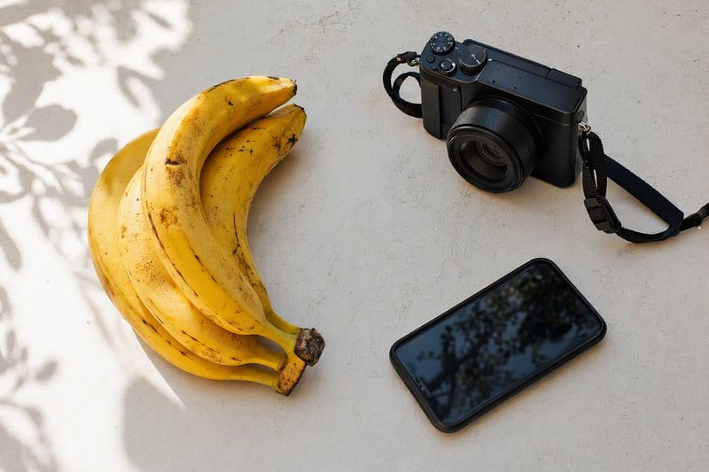 A desk with a phone, a printed photograph and a laptop showing a half finished edit
