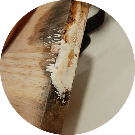 Planche à découper en bois usée avec des résidus le long du bord