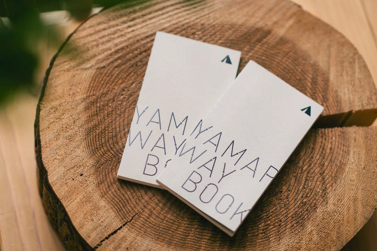 切り株の上に置かれた『YAMAP WAY BOOK』