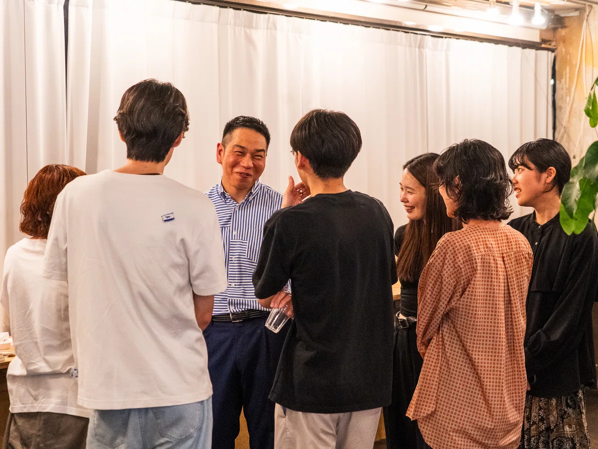 藤原印刷の社員とお客さんが笑顔で歓談する交流イベントの様子