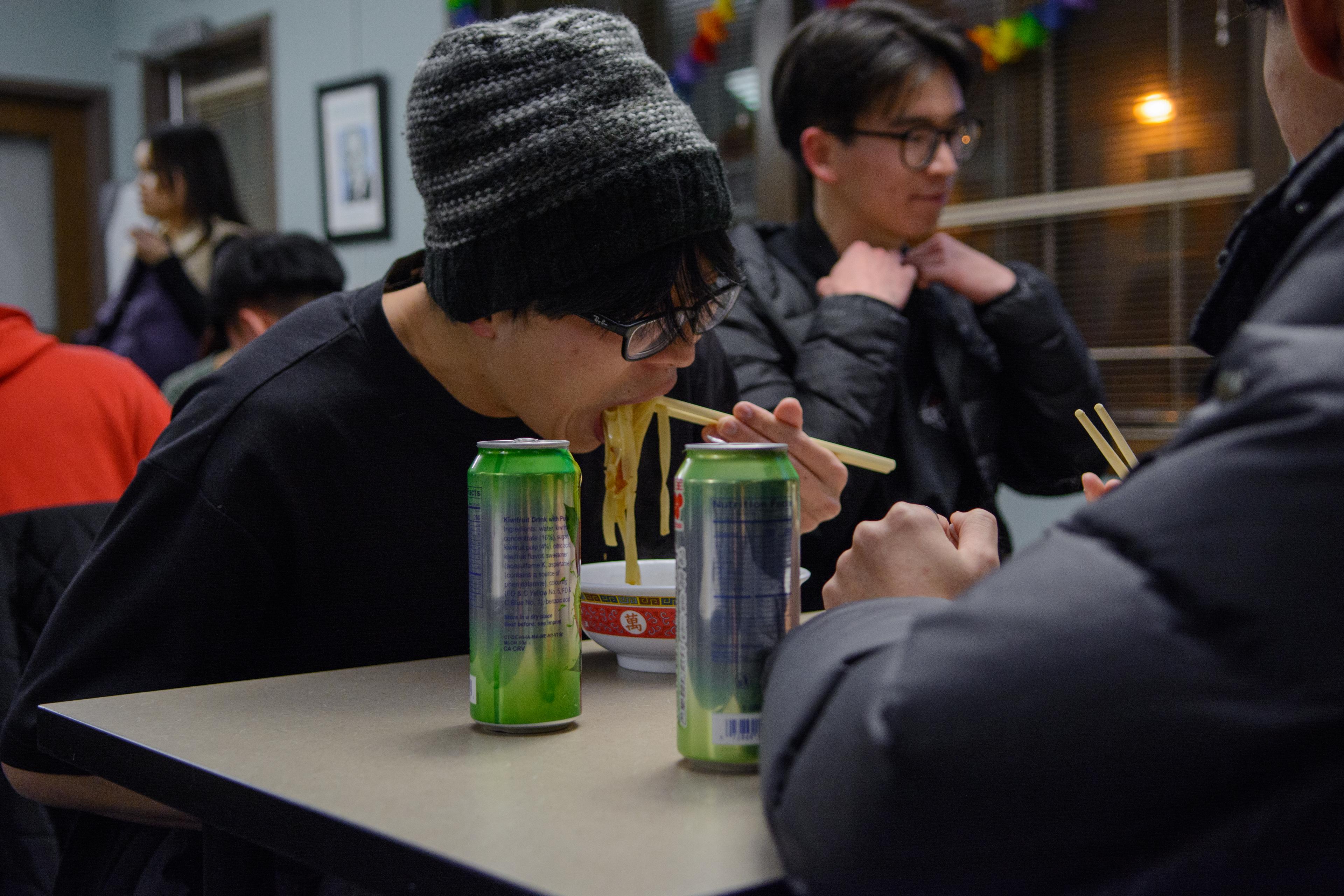 TASC member hastily eating a bowl of beef noodle soup.