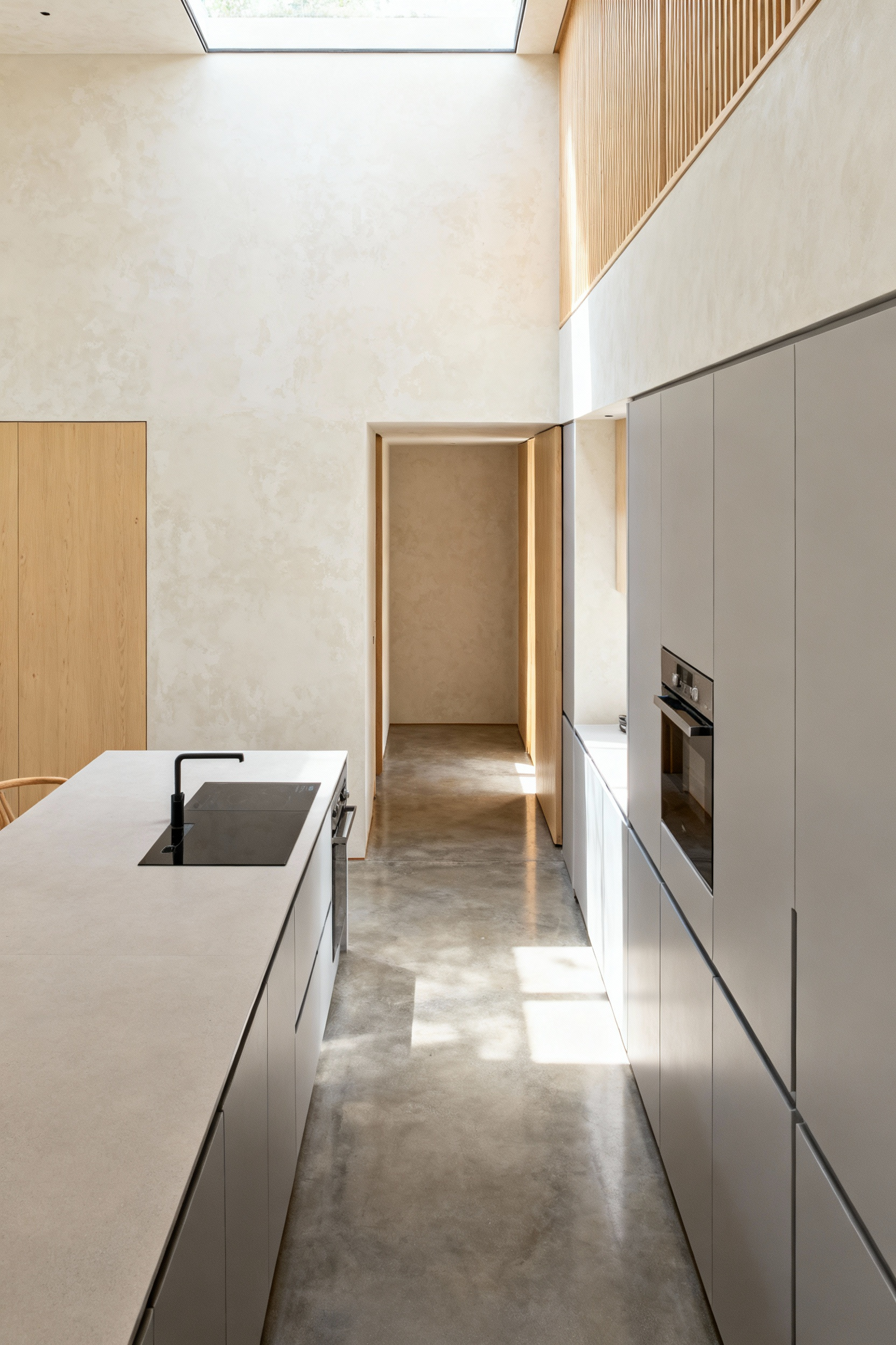 A minimalist Zen kitchen featuring clean lines, handle-less cabinetry, and uncluttered surfaces, showcasing the 'Ma' principle of intentional negative space for a serene atmosphere.