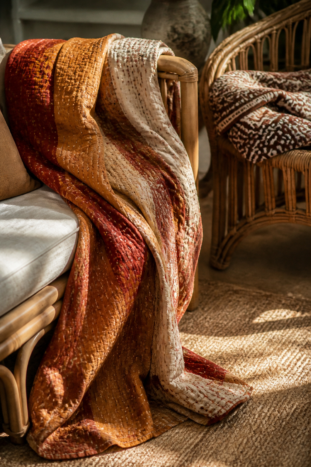 A hand-stitched kantha quilt and West African mudcloth throw, draped in the unhurried way of textiles that are genuinely used, add story and warmth to the boho seating arrangement.