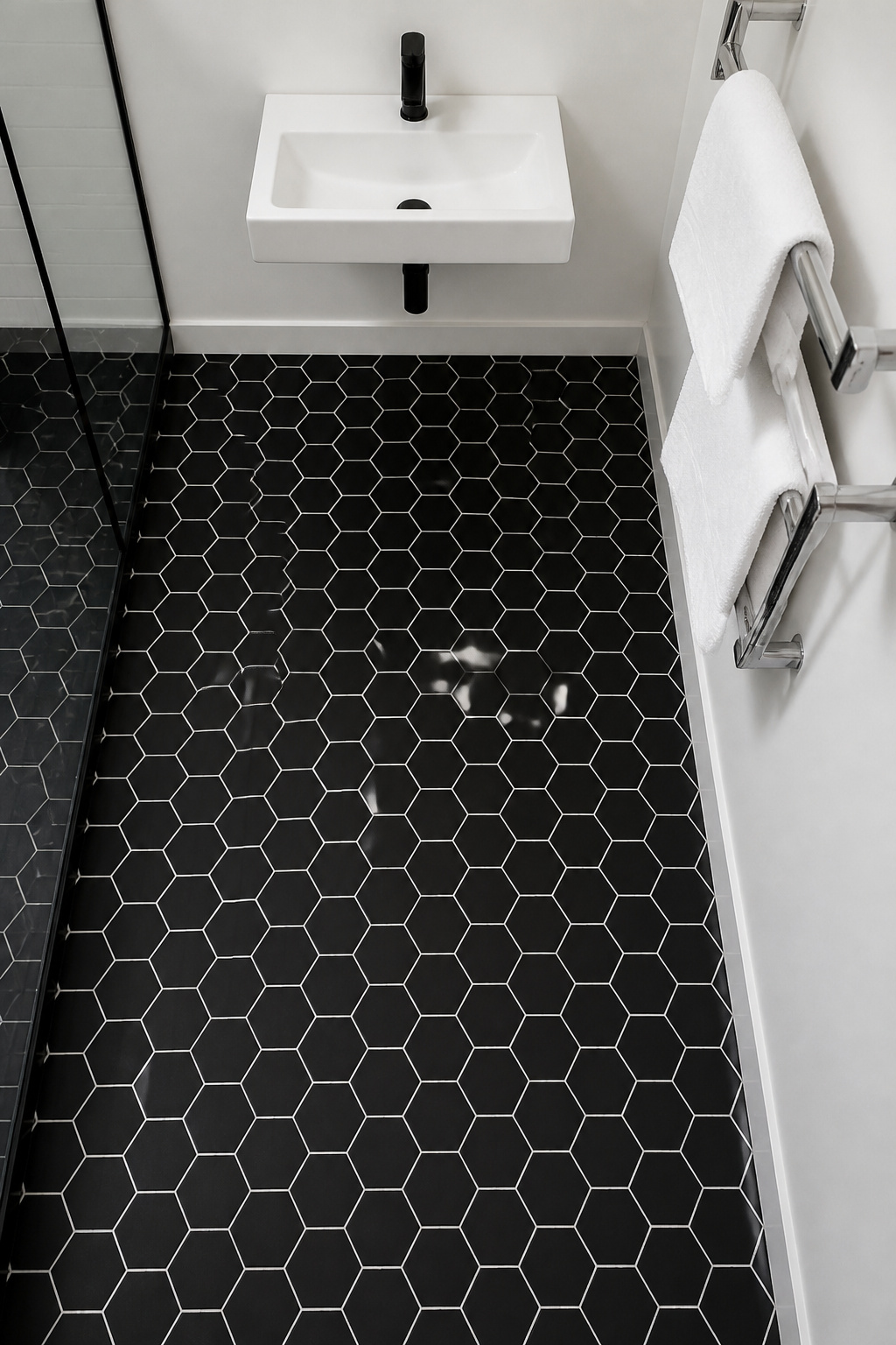 Black hexagon floor tiles with white grout — a graphic bathroom tile design where the geometric pattern reads clearly without making the room feel heavy or dark.
