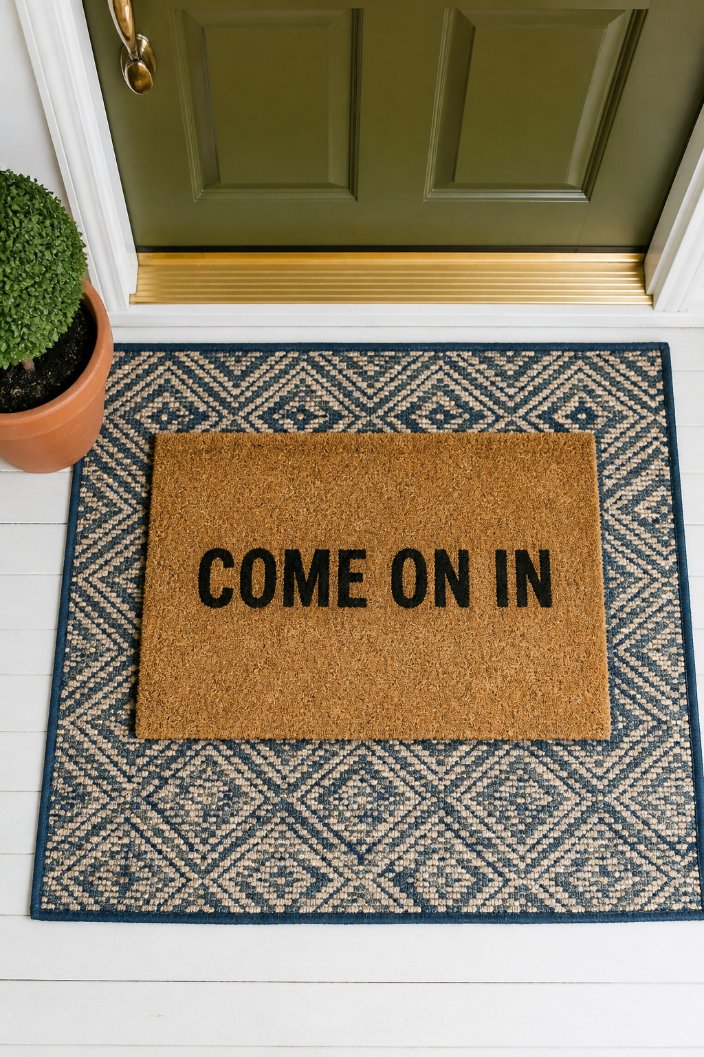 The double-doormat technique — large patterned base layer plus smaller personality mat on top — costs $30-50 total and reads as designed rather than purchased.