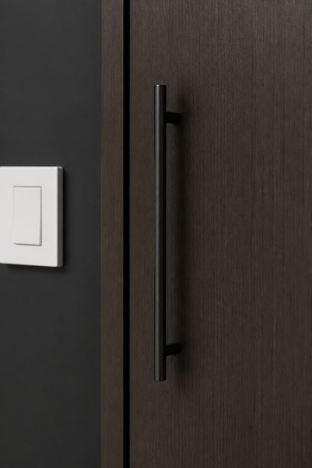 Matte black bar pulls, rods, and switch plates repeat the same tonal note across every functional surface — the detail work that distinguishes a designed room from a decorated one.