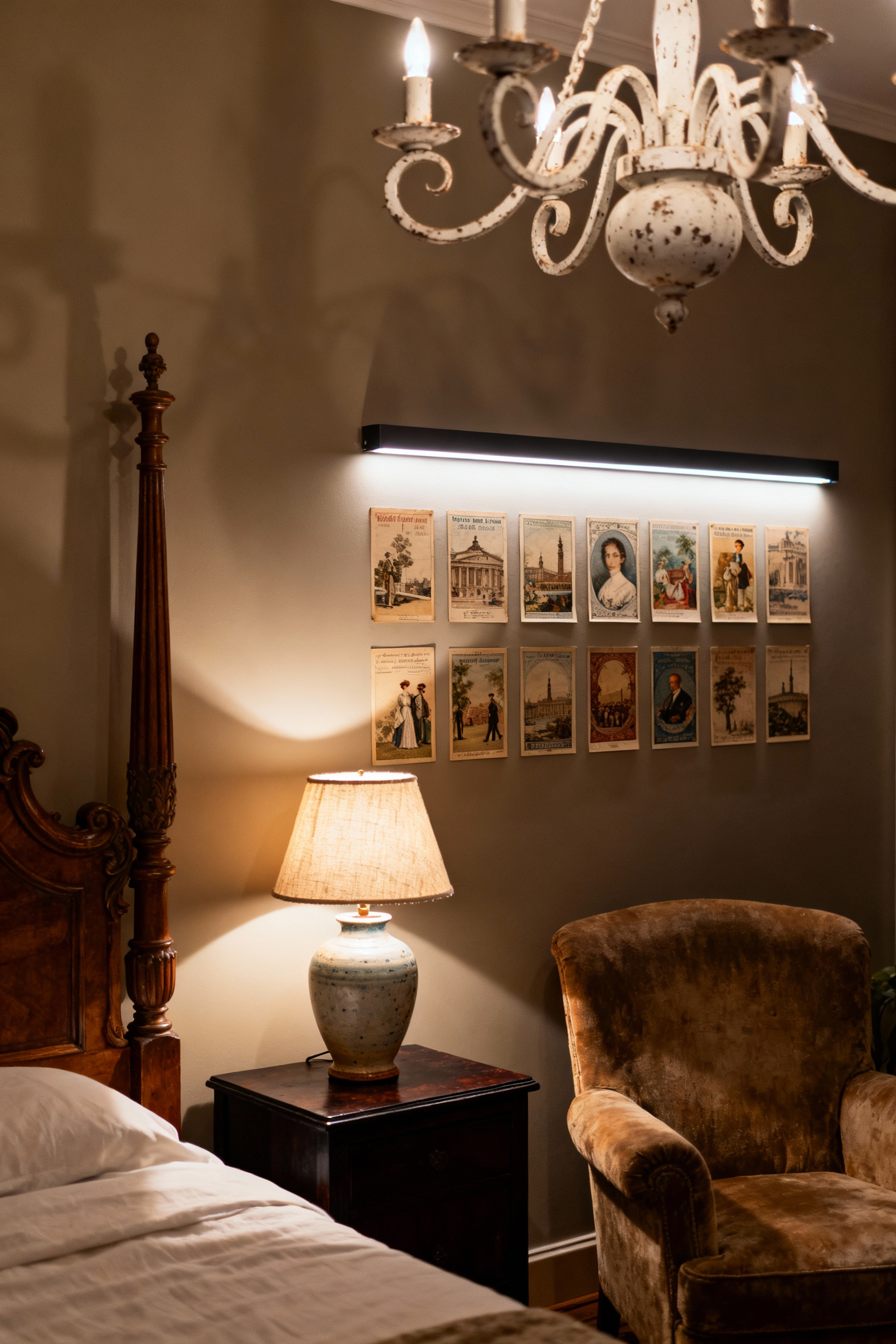 A vintage-inspired bedroom with three layers of lighting: a central chandelier for ambient light, a bedside lamp for task lighting, and subtle accent lights on a gallery wall of vintage postcards, creating a warm and cozy atmosphere.