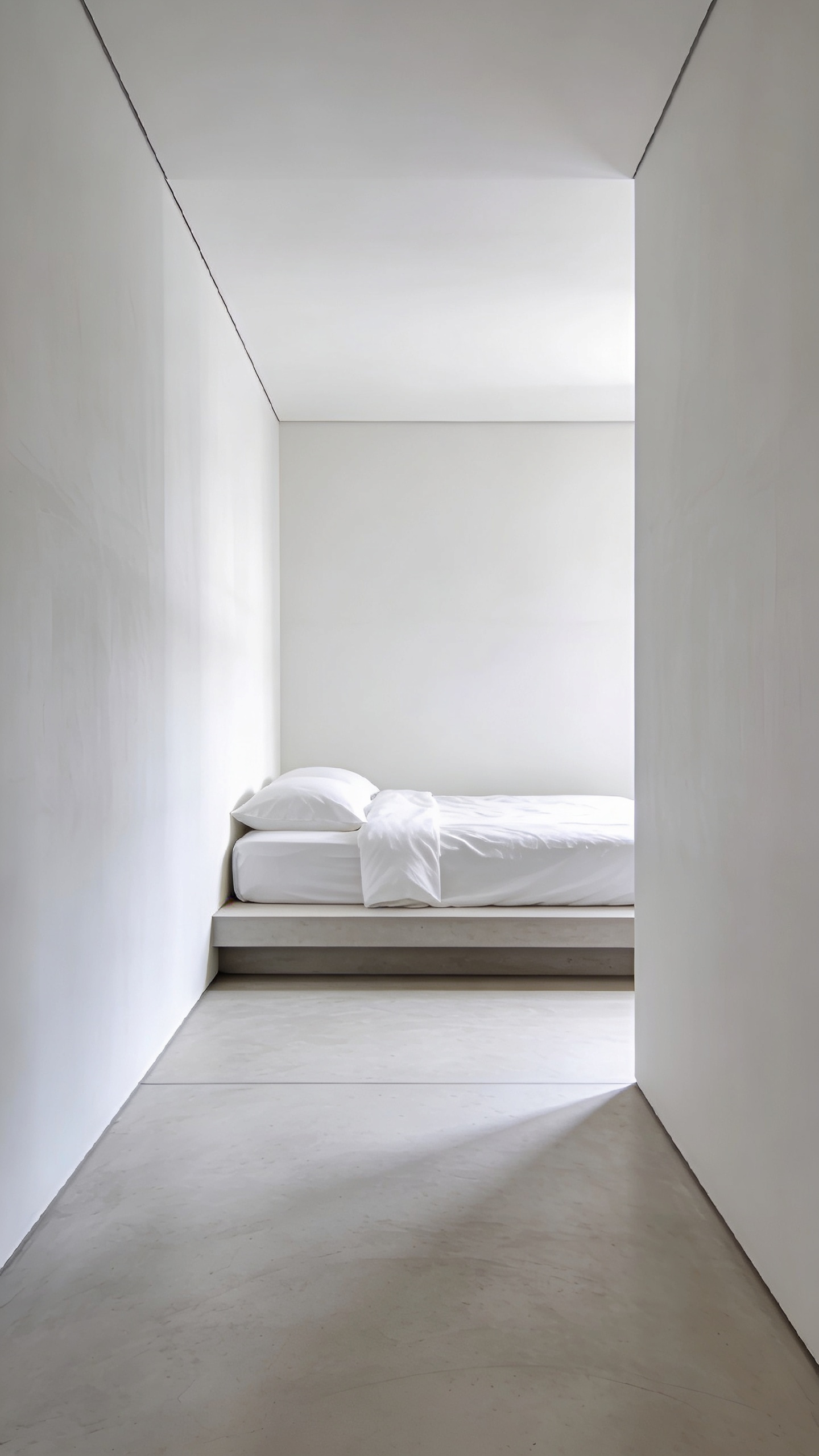 A pristine, minimalist bedroom corner showing a seamless, trim-less intersection between the matte white wall and the polished concrete floor, symbolizing structural purity and clean lines.