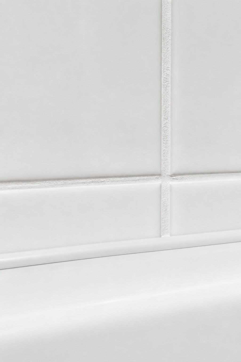 Fresh grout and clean caulk lines transform old tile for under $100 in DIY materials — the single highest-value-per-dollar update in any dated bathroom.