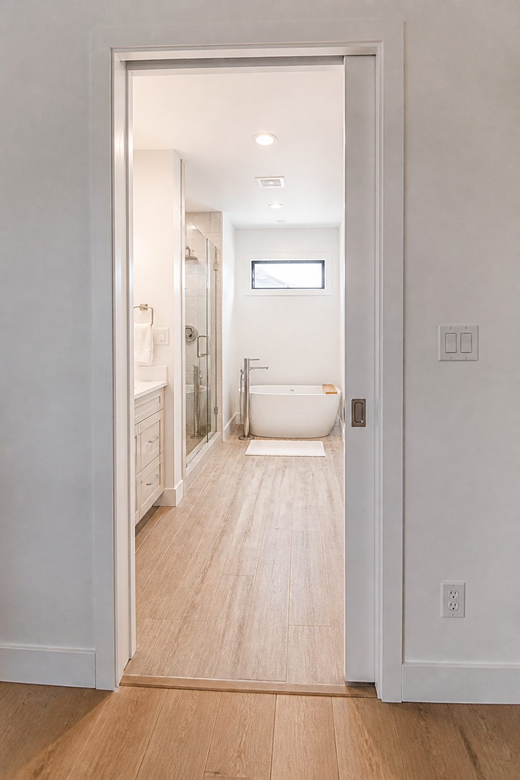 A pocket door eliminates the full door-swing clearance requirement, immediately freeing up significant floor space in a compact bathroom.