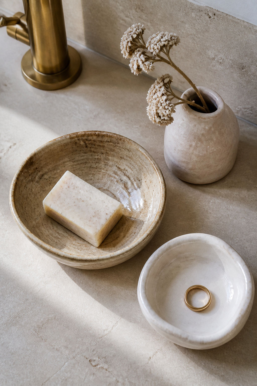Artisan ceramics in dune, oyster, and shell — the accessories layer that makes a coastal bathroom feel like a considered home.