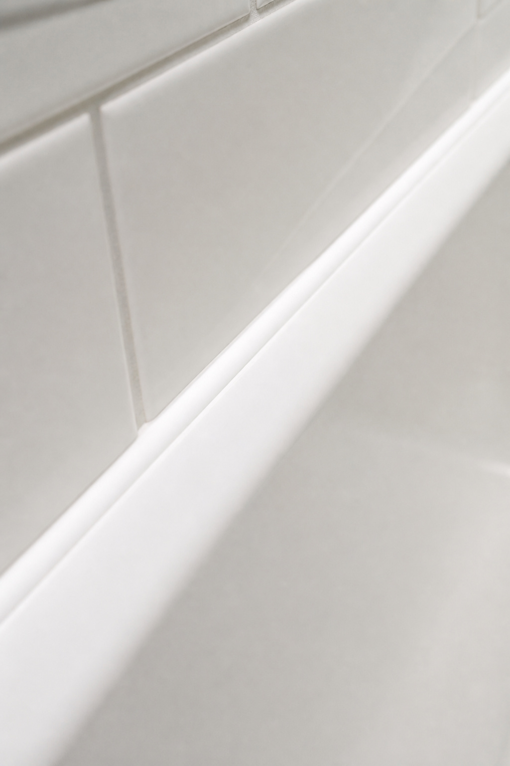 A fresh bead of 100% silicone caulk at the tub-tile joint — the most effective $10 budget bathroom renovation improvement in any bathroom that hasn't been touched in years.