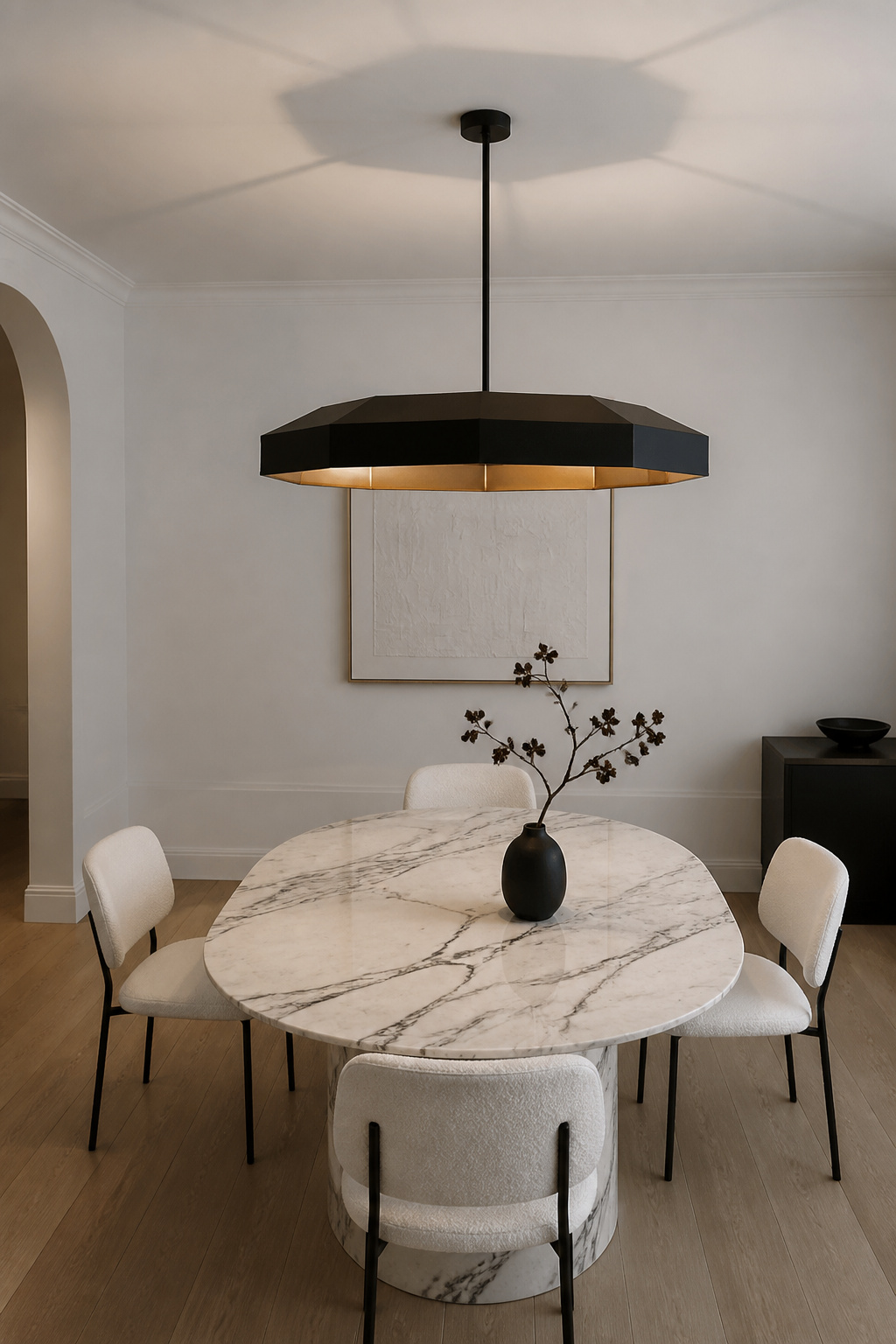A matte black octagonal pendant with a brass interior rim creates sharp contrast above white Carrara marble — the graphic quality of this fixture works hardest in light-toned rooms.