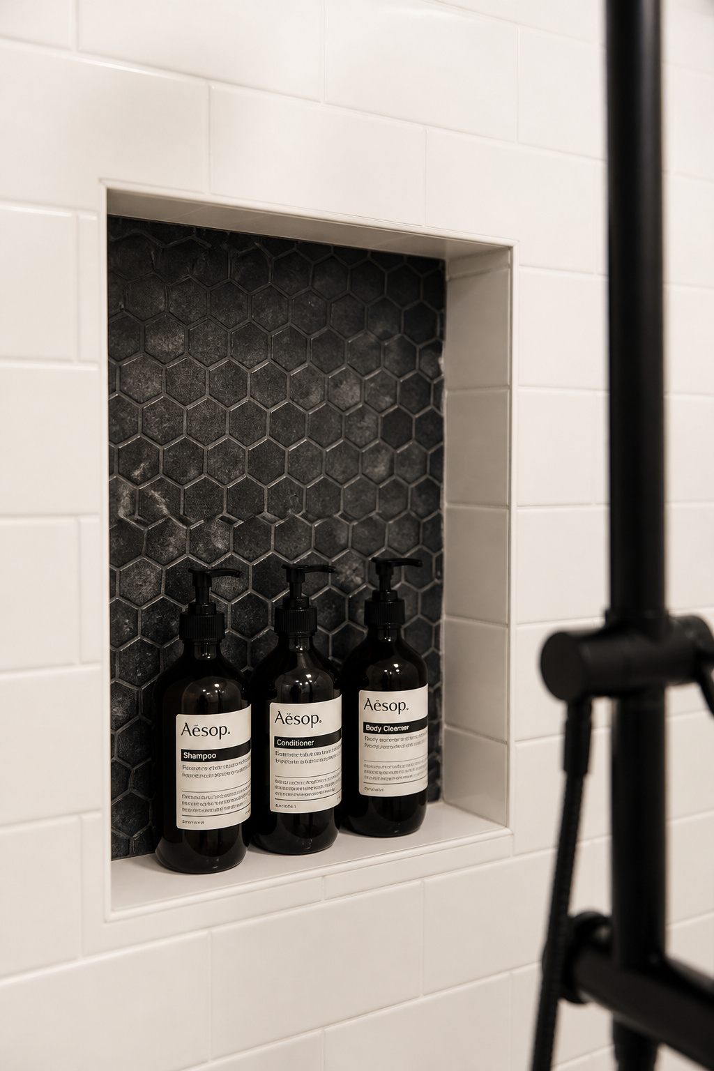 A recessed shower niche tiled in contrasting mosaic — the storage bathroom design idea that becomes an architectural detail.