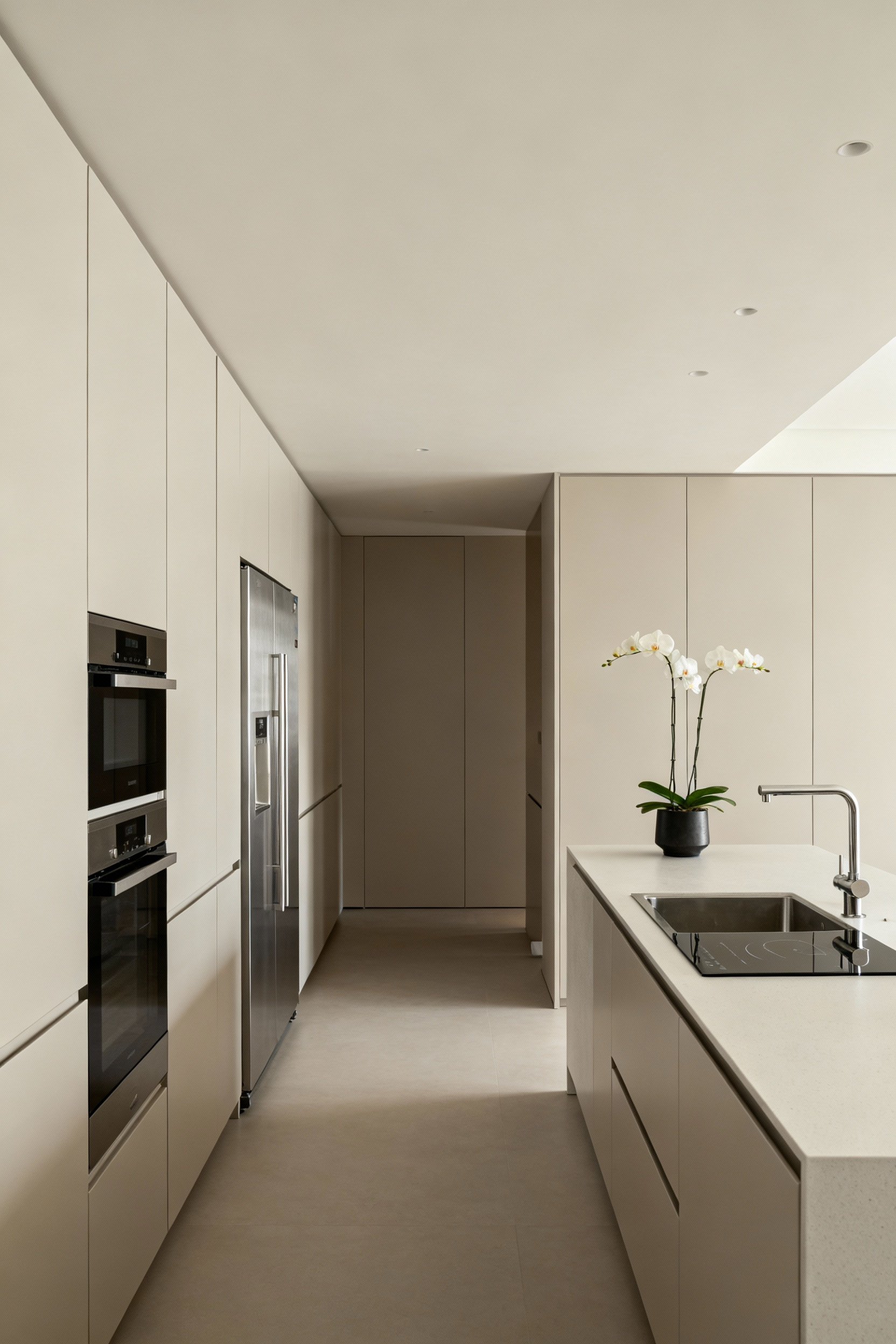 Modern kitchen interior showcasing an intuitive culinary workflow with seamless design, elegant minimalist cabinetry, clean quartz countertops, and abundant natural light.