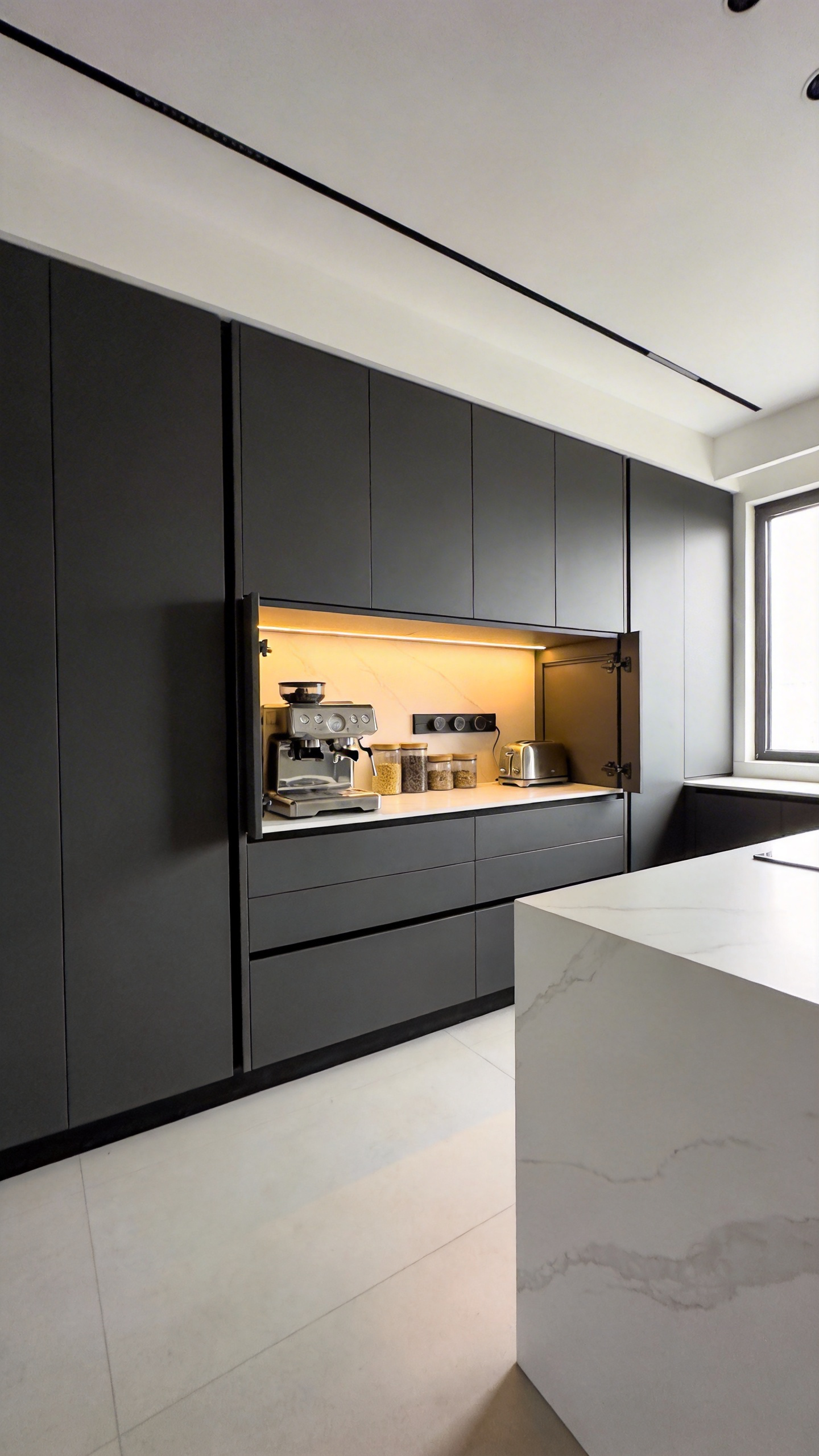 A modern kitchen renovation showing a floor-to-ceiling hidden breakfast station with pocket doors open to reveal kitchen appliances and integrated lighting.