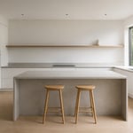 A complete minimalistic kitchen in warm white and grey — handleless, bare-surfaced, natural-light-filled — where every decision has been made to create a room that asks nothing of you except that you be in it.