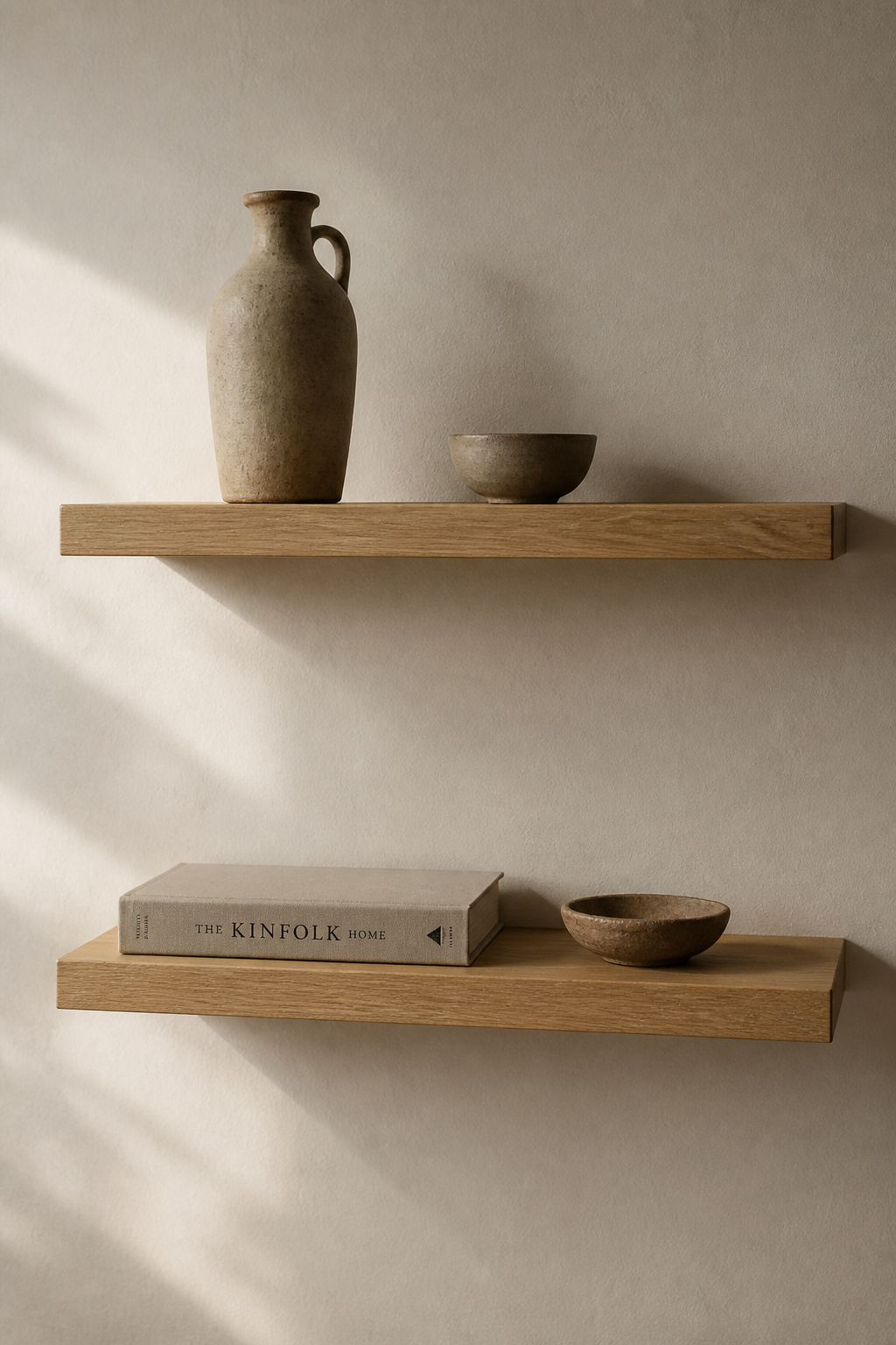 Two oak floating shelves holding four objects between them — each with as much space around it as the shelf itself contains.