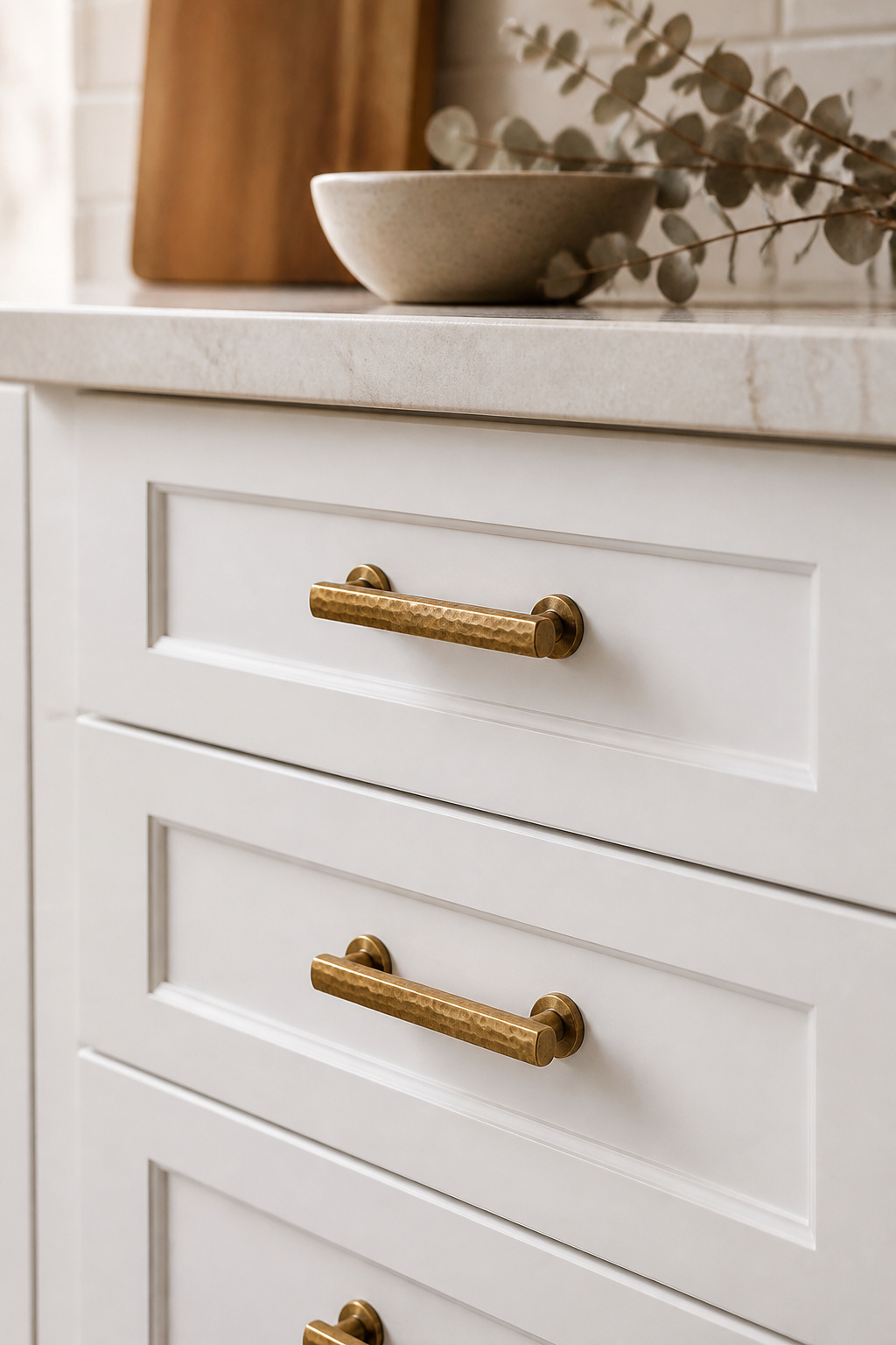 Unlacquered brass bar pulls replace builder-grade knobs on these white Shaker cabinets — a $200 update that reads as a $2,000 renovation.