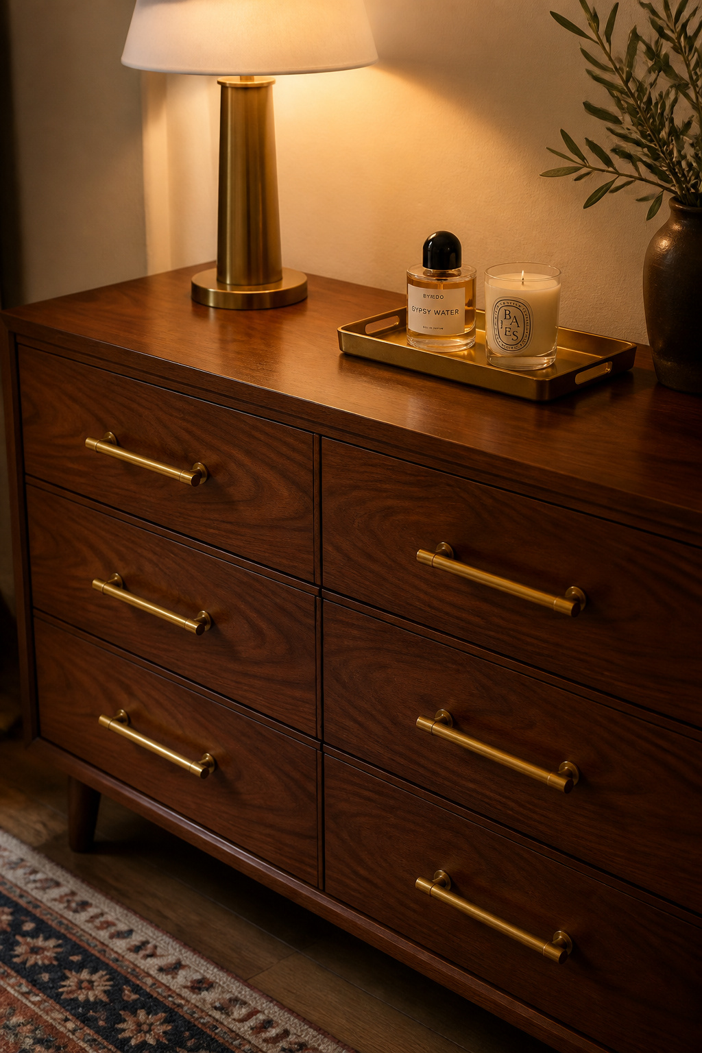 Unlacquered brass bar pulls on a walnut dresser — a hardware upgrade that costs under $120 and transforms the piece entirely after dark.
