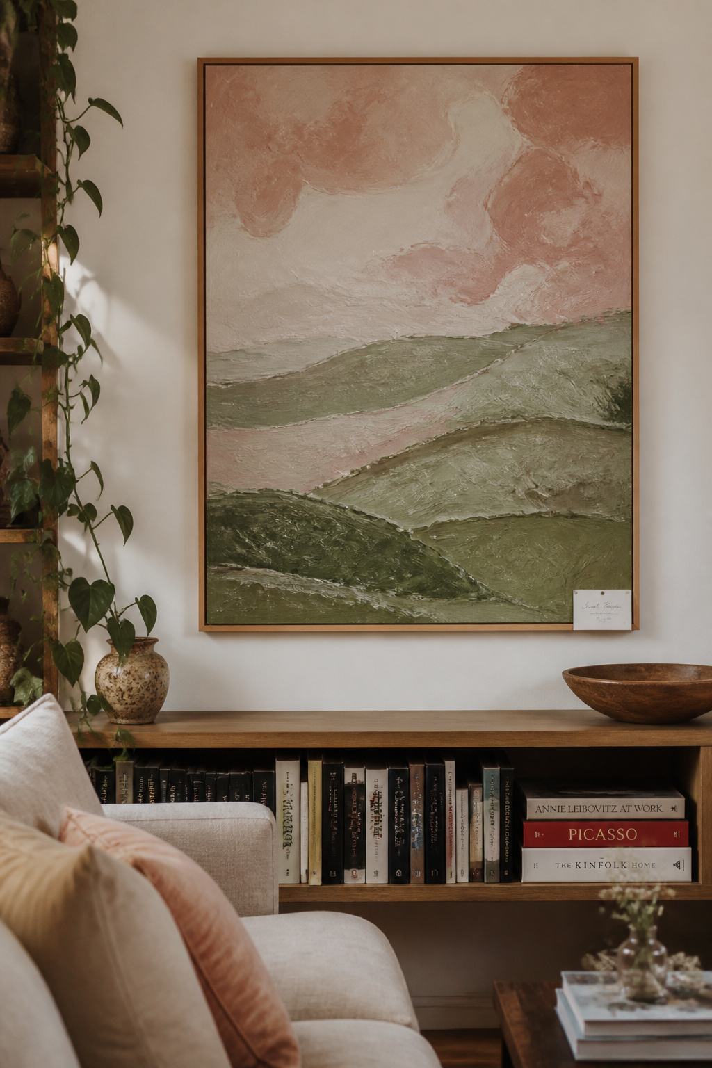 An original oil painting from a local artist brings irreplaceable human presence to this living room. The small artist card beside it transforms the display from decoration into a story worth telling.